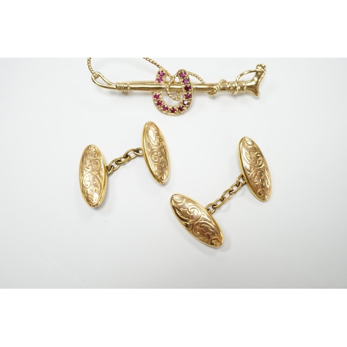 2054 - A pair of George V engraved 9ct gold oval cufflinks and a yellow metal and ruby cluster set horsesho... 