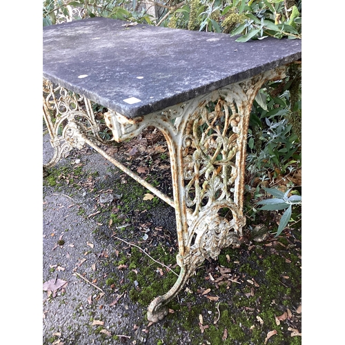 189 - A Victorian painted cast iron garden table with weathered marble top, together with a similar table ... 