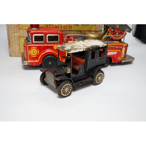 276 - Four tinplate toys; a model of a 1920s taxi, a 1960s German made fire engine, an automaton clown, an... 