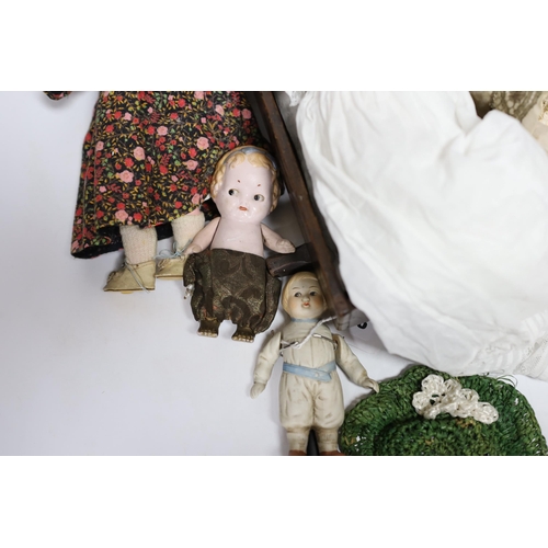 298 - Nine assorted dolls including AMS and Kewpie small doll baby in cradle