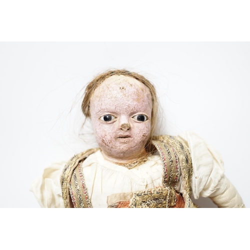 304 - An early 19th century doll with a papier mache head, glass eyes and kid leather body, dressed in 18t... 