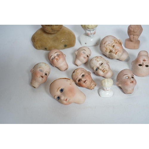 331 - Twelve small bisque doll heads and a wax head