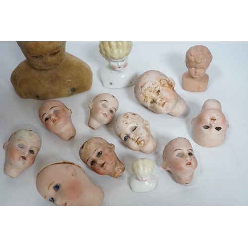 331 - Twelve small bisque doll heads and a wax head