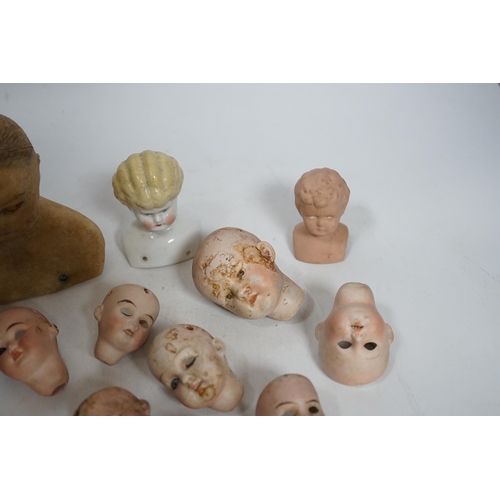 331 - Twelve small bisque doll heads and a wax head