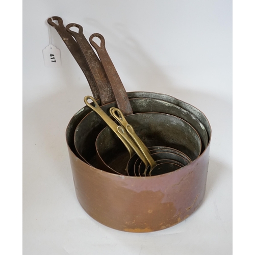 417 - A copper two handled jam pan and a graduated set of eight copper saucepans