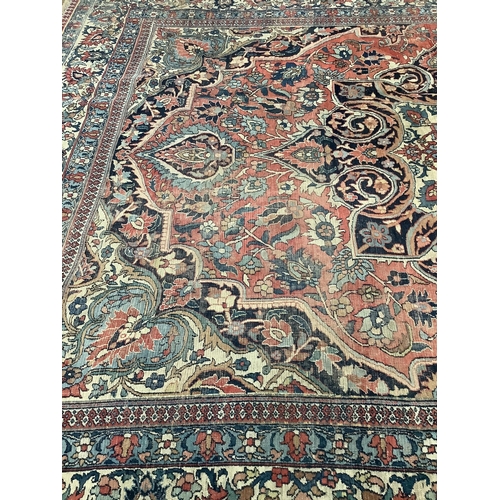 66 - An early 20th century Heriz burgundy ground carpet, 380 x 276cm