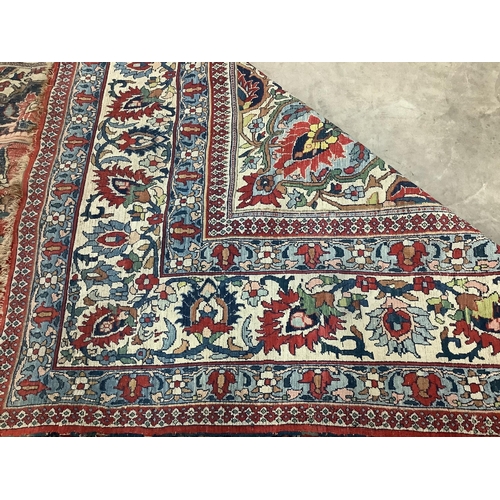 66 - An early 20th century Heriz burgundy ground carpet, 380 x 276cm