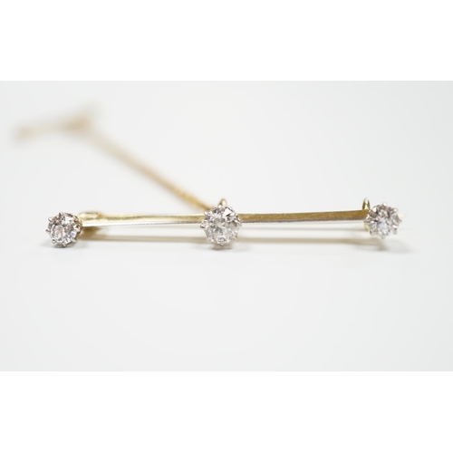 939 - A yellow metal and three stone diamond set bar brooch, 37mm, with safety chain, gross weight 3 grams... 