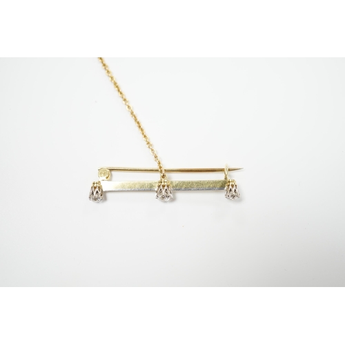 939 - A yellow metal and three stone diamond set bar brooch, 37mm, with safety chain, gross weight 3 grams... 
