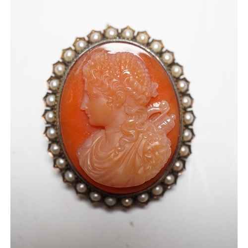 945 - A Victorian yellow metal, and seed pearl mounted oval hardstone cameo pendant brooch, carved with th... 