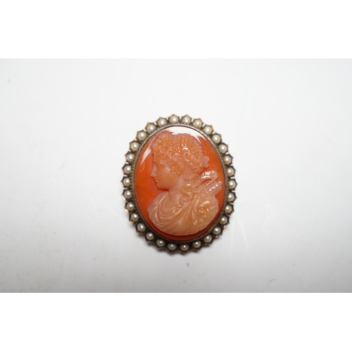 945 - A Victorian yellow metal, and seed pearl mounted oval hardstone cameo pendant brooch, carved with th... 