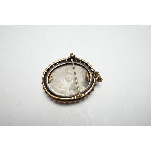 945 - A Victorian yellow metal, and seed pearl mounted oval hardstone cameo pendant brooch, carved with th... 