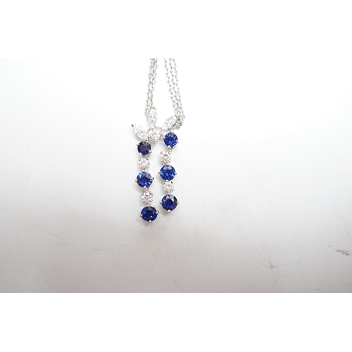 955 - A modern 750 white metal, sapphire and diamond set cluster pendant, 31mm, on a twin strand white met... 