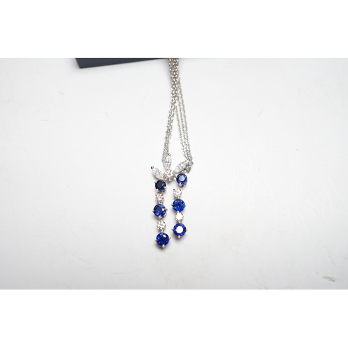 955 - A modern 750 white metal, sapphire and diamond set cluster pendant, 31mm, on a twin strand white met... 