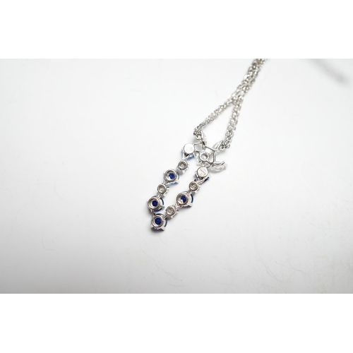955 - A modern 750 white metal, sapphire and diamond set cluster pendant, 31mm, on a twin strand white met... 