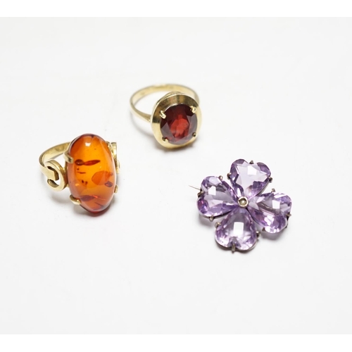 956 - A 333 yellow metal and amber set ring, a 585 and gem set ring and an amethyst and seed pearl set whi... 