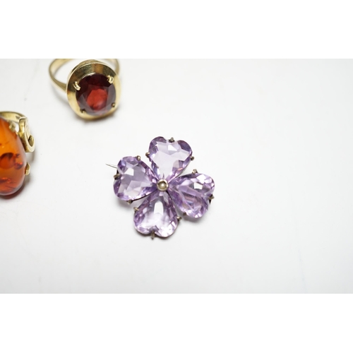 956 - A 333 yellow metal and amber set ring, a 585 and gem set ring and an amethyst and seed pearl set whi... 