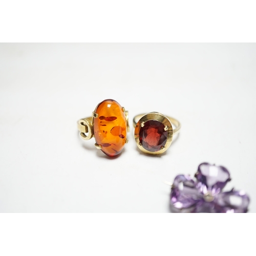 956 - A 333 yellow metal and amber set ring, a 585 and gem set ring and an amethyst and seed pearl set whi... 
