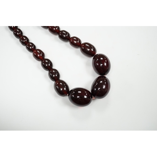 980 - A single strand graduated simulated cherry amber bead necklace, 68cm, gross weight 151 grams.