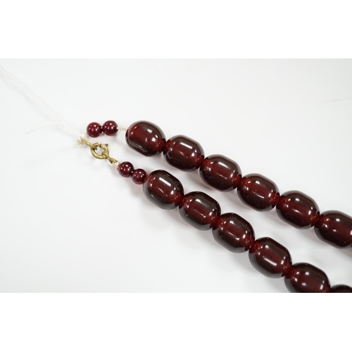 980 - A single strand graduated simulated cherry amber bead necklace, 68cm, gross weight 151 grams.