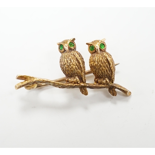 985 - An Edwardian 15ct novelty brooch, modelled as two owls perched on a branch, with four stone green ga... 