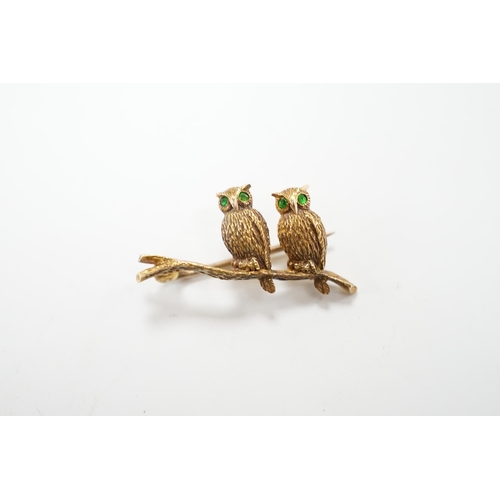 985 - An Edwardian 15ct novelty brooch, modelled as two owls perched on a branch, with four stone green ga... 