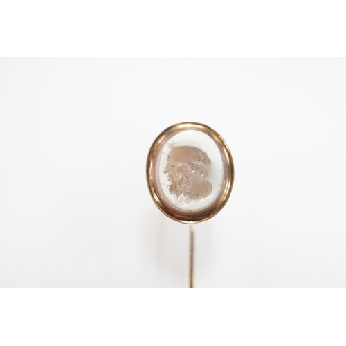 991 - An early 20th century yellow metal and oval intaglio chalcedony set stick pin, 77mm.