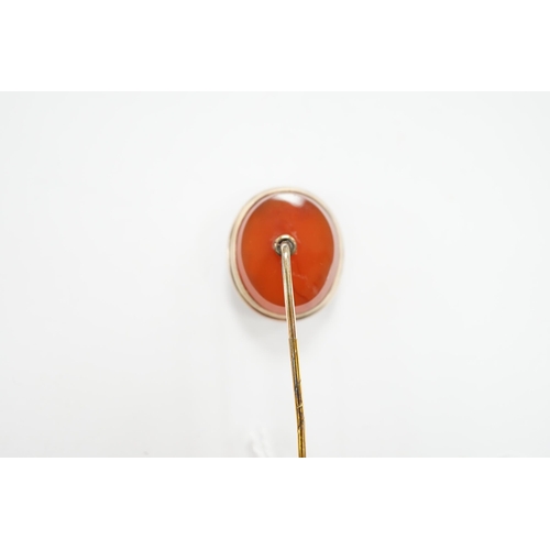 991 - An early 20th century yellow metal and oval intaglio chalcedony set stick pin, 77mm.