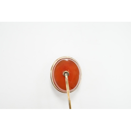 991 - An early 20th century yellow metal and oval intaglio chalcedony set stick pin, 77mm.