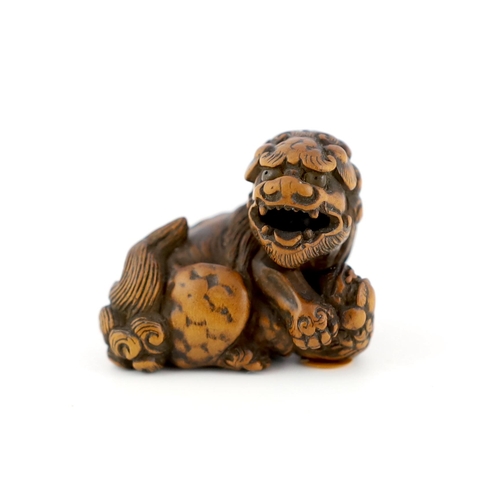 148 - * * A Japanese carved wood netsuke of a recumbent Shi-Shi, signed Toyomasa?, late 18th century, with... 