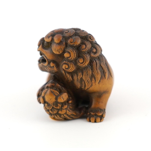 148 - * * A Japanese carved wood netsuke of a recumbent Shi-Shi, signed Toyomasa?, late 18th century, with... 