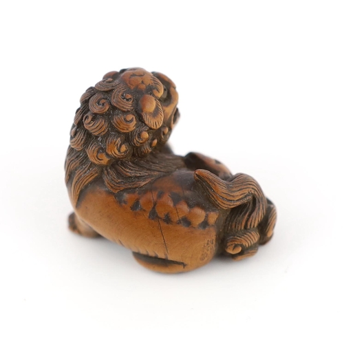 148 - * * A Japanese carved wood netsuke of a recumbent Shi-Shi, signed Toyomasa?, late 18th century, with... 