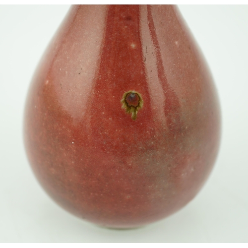 167 - A Chinese copper red small bottle vase, 18th/19th century, of pear shape, underglaze blue double cir... 