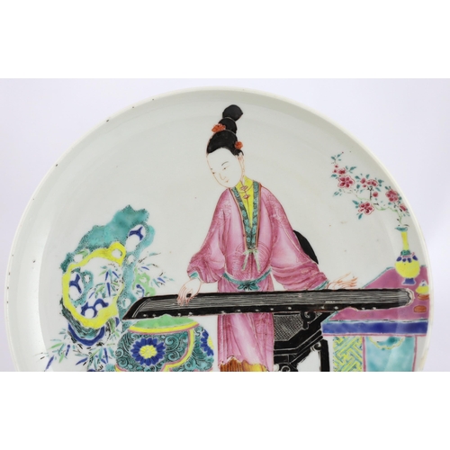 170 - * * A Chinese famille rose saucer dish, Yongzheng period, painted in enamels with a young woman play... 