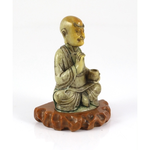 226 - A Chinese soapstone seated figure of a luohan, 18th century, seated holding a begging bowl in his le... 