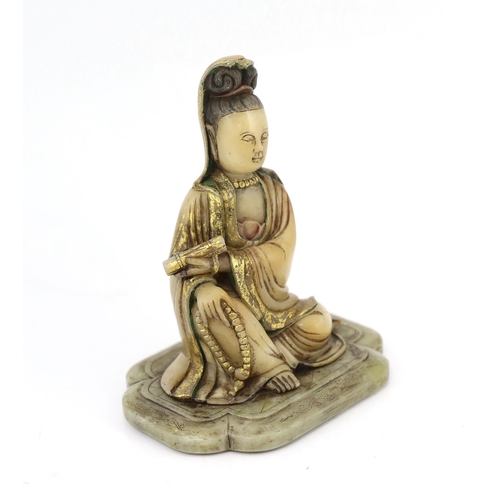 227 - A Chinese soapstone seated figure of Guanyin, 17th/18th century, holding a scroll in the left hand a... 