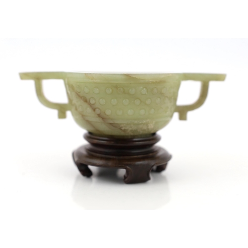 236 - A Chinese celadon jade two handled cup, 17th century, decorated with a band of archaistic studs, wit... 