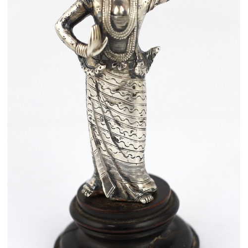 242 - A Burmese cast silver model of a dancer, late 19th century, on an ebonised wood plinth, total height... 