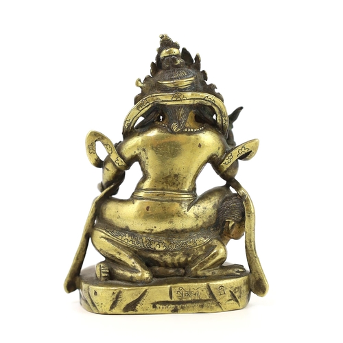 243 - * * A Tibetan gilt bronze figure of a deity, 17th century, holding a purba in his right hand, seated... 