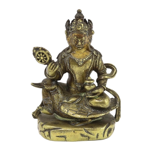 244 - * * A Tibetan gilt bronze figure of a bodhisattva, 17th century, with four faces, holding a wheel an... 