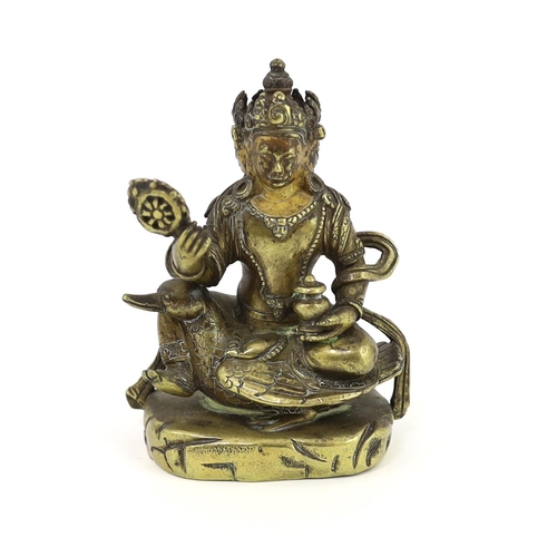 244 - * * A Tibetan gilt bronze figure of a bodhisattva, 17th century, with four faces, holding a wheel an... 