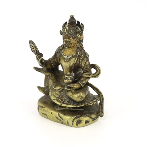 244 - * * A Tibetan gilt bronze figure of a bodhisattva, 17th century, with four faces, holding a wheel an... 