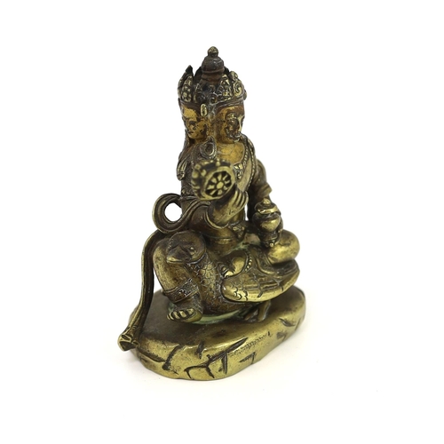 244 - * * A Tibetan gilt bronze figure of a bodhisattva, 17th century, with four faces, holding a wheel an... 