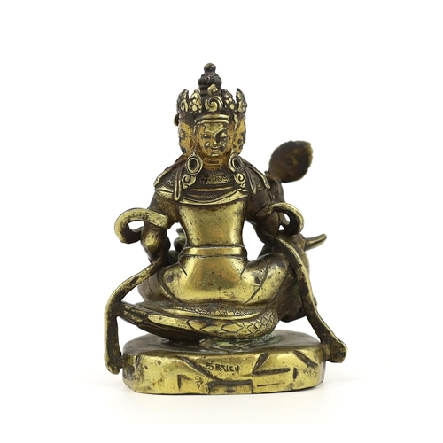 244 - * * A Tibetan gilt bronze figure of a bodhisattva, 17th century, with four faces, holding a wheel an... 