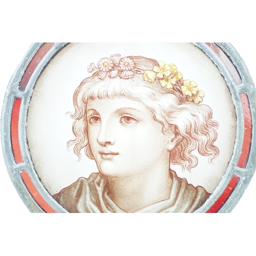 57 - A Victorian stained glass roundel, depicting a Pre-Raphaelite youth with flowers in his hair, within... 