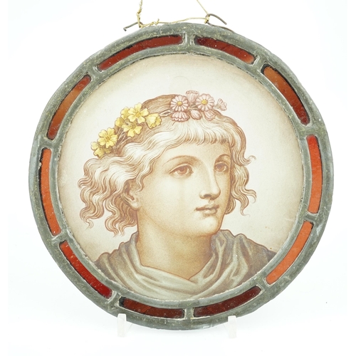 57 - A Victorian stained glass roundel, depicting a Pre-Raphaelite youth with flowers in his hair, within... 