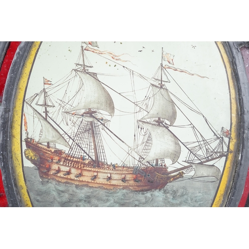 59 - An early 18th century stained glass panel, depicting a warship off the coast, within a later red gla... 