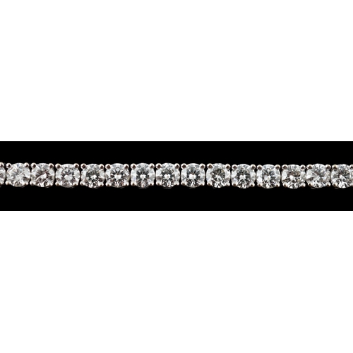 613 - An 18k white gold and diamond line bracelet, set with forty eight round brilliant cut stones with an... 