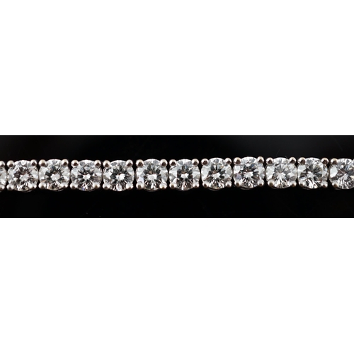 613 - An 18k white gold and diamond line bracelet, set with forty eight round brilliant cut stones with an... 