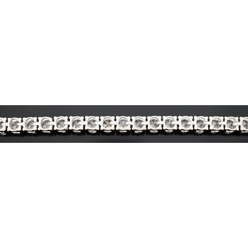 613 - An 18k white gold and diamond line bracelet, set with forty eight round brilliant cut stones with an... 